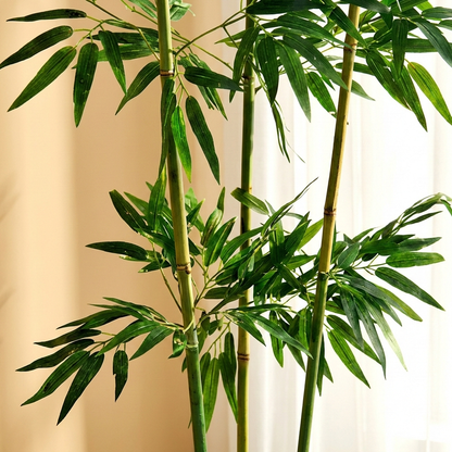 A studio shot against a solid white background showing four realistic artificial bamboo stalks featuring detailed dark green, lance-shaped indoor bamboo plant leaves with specifications.