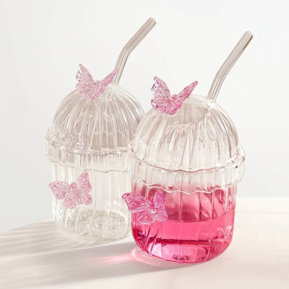 Clear ribbed glass tumbler with lid, glass straw, and 3D pink butterfly decorations on a white background main image