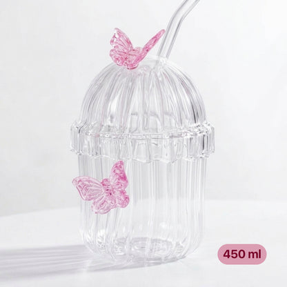 Clear ribbed glass tumbler with lid, glass straw, and 3D pink butterfly decorations on a white background.