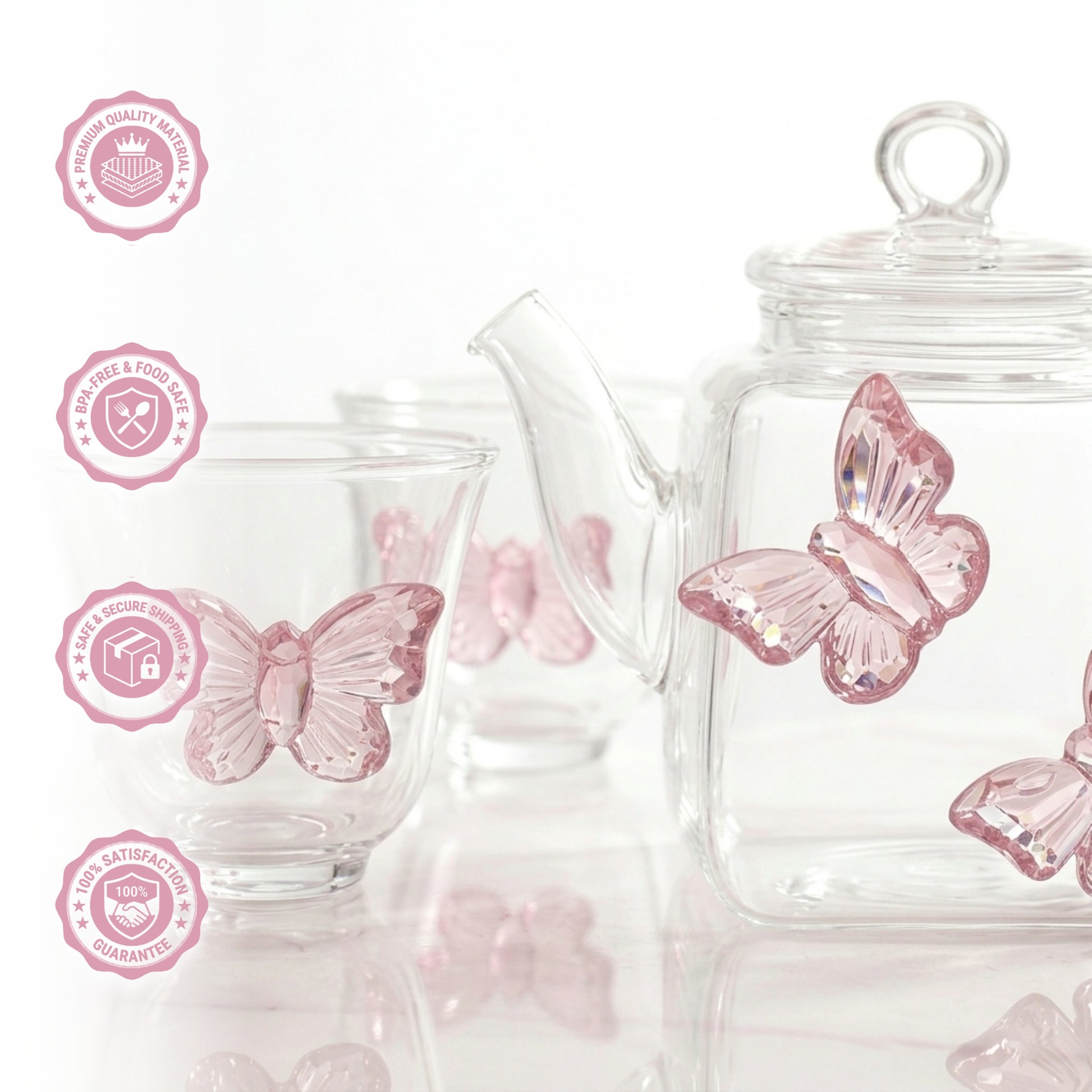 Close-up macro photograph of a clear glass teapot and teacup, highlighting the intricate glasswork, light reflection, and texture of the attached 3D pink butterfly decorations.