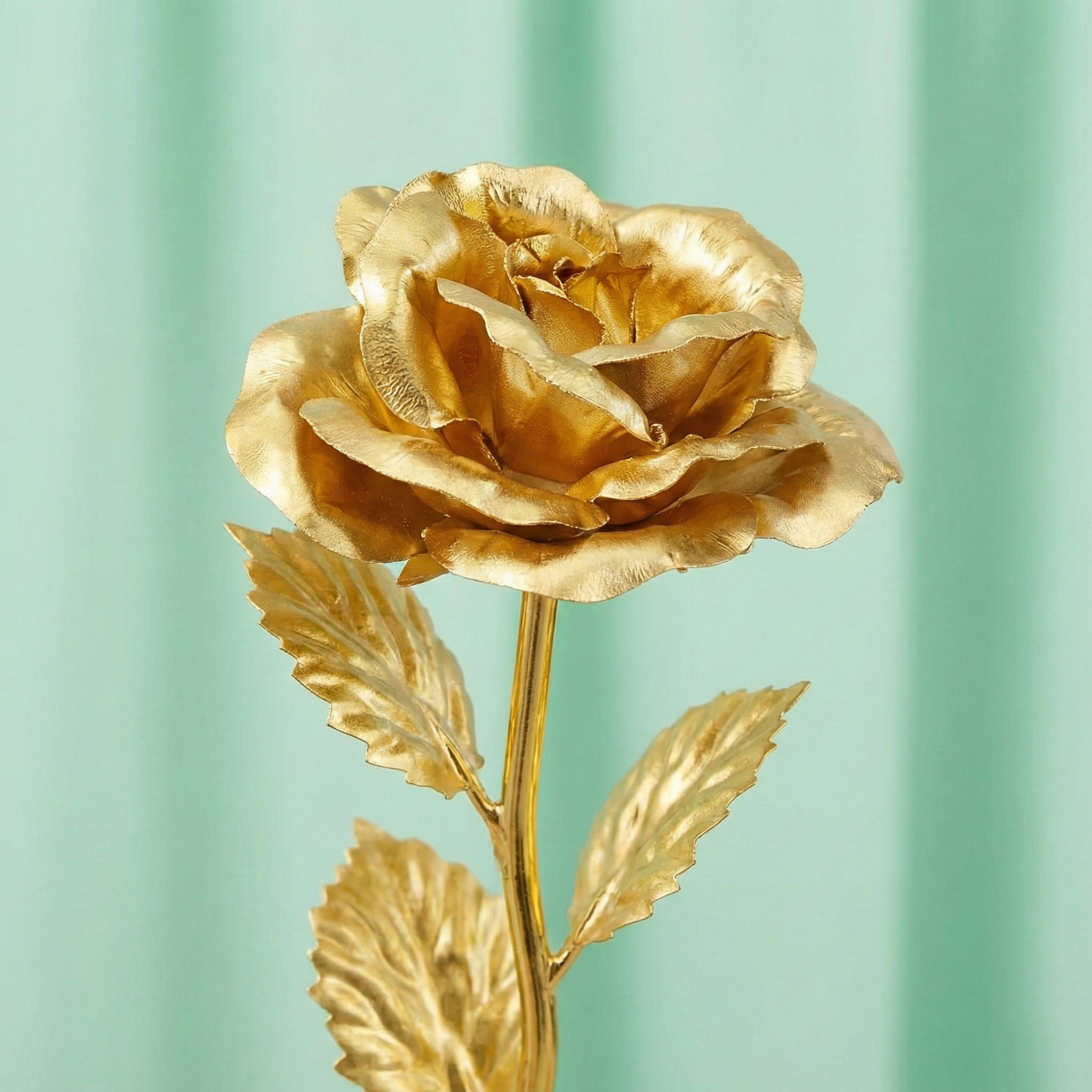 Close up detail showing the metallic gold finish on the petals of the artificial eternal rose