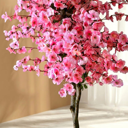 Close-up detail of vibrant pink petals and delicate branches on a lifelike faux cherry blossom plant