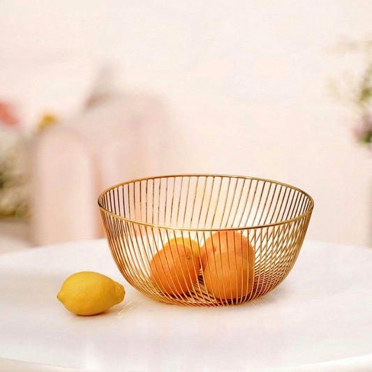 Sleek 10x10 inch gold metal wire basket on a solid white surface, styled as a modern minimalist fruit bowl containing oranges.