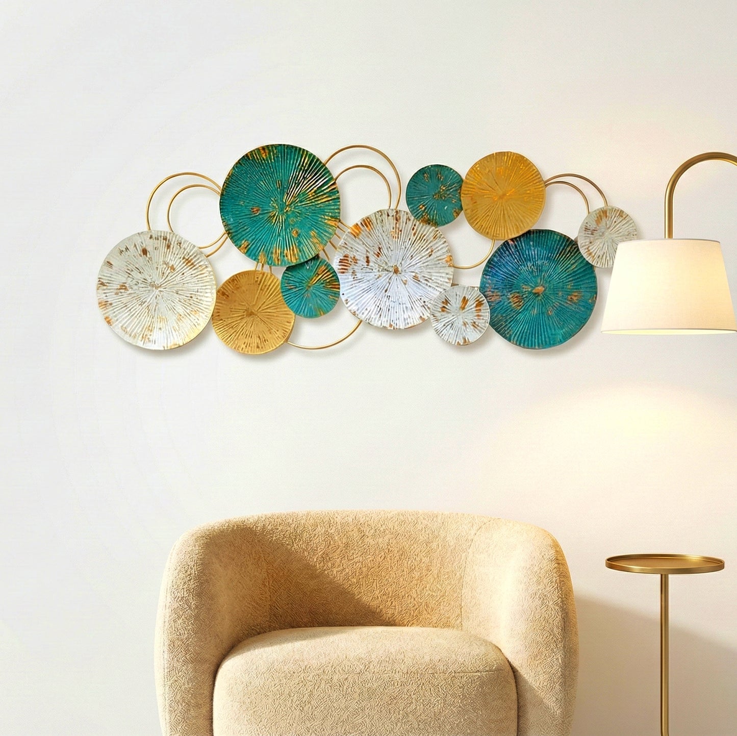 Modern teal and gold metal wall art hanging above a beige armchair