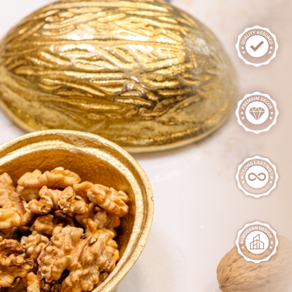 Studio shot of a two-piece metallic gold decorative bowl shaped like a large walnut, open to reveal actual walnuts inside against a solid white background.